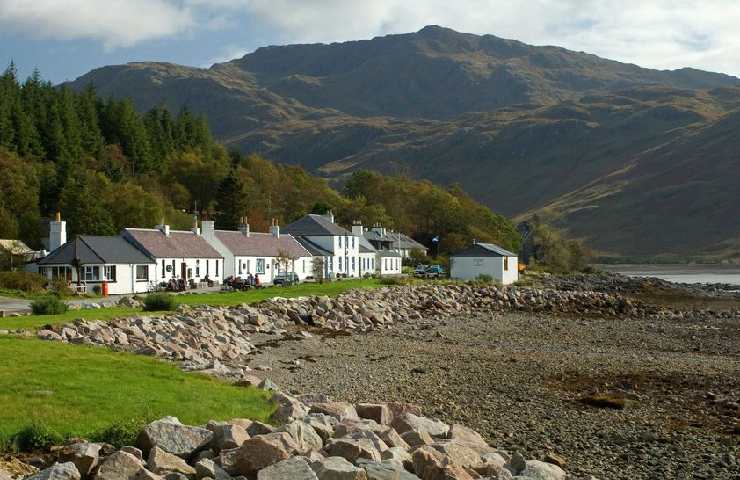 Piccolo villaggio scozzese di Inverie davanti al mare e con dietro le montagne delle Highlands