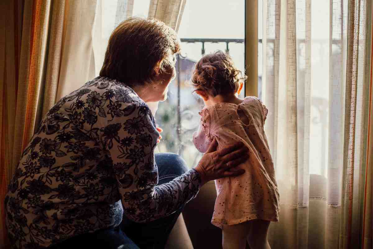 Nonna e nipote davanti ad una finestra in controluce che giocano