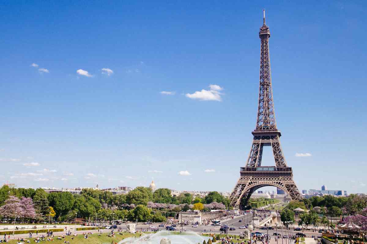 Vista frontale della Tour Eiffel che appare a destra della foto sopra a Parigi in una giornata con il cielo terso